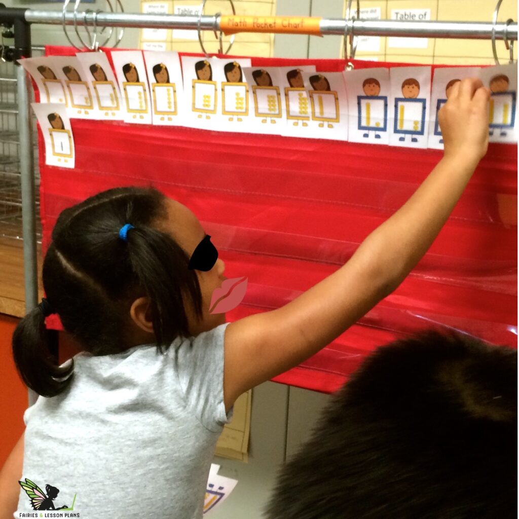 Students ordering base ten flashcards on a pocket chart.